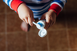 arial view of a small child putting toothpaste on a toothbrush