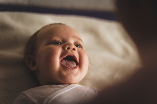 A baby smiling at her mama.