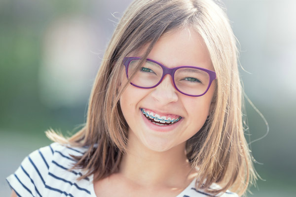 Young girl with braces smiling.