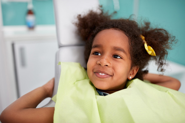 Adorable smiling girl in dental chair.