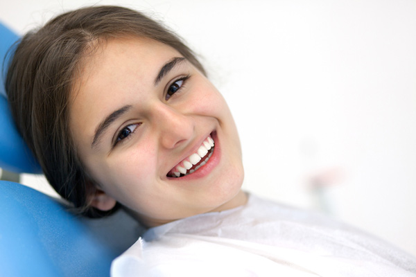 Smiling teenager sitting in dental chair.