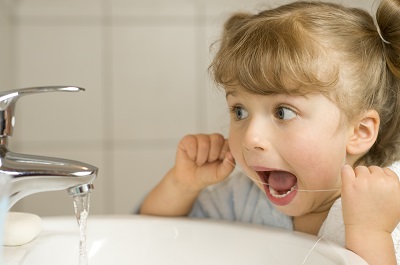 Little girl trying to floss