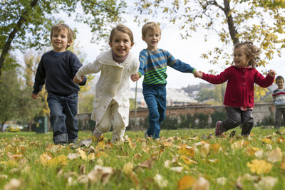 Children running in the fall leaves